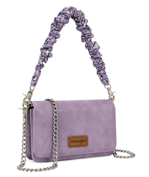 A purple faux-leather shoulder bag with a silver chain strap and a wide, ruched purple shoulder strap. The bag features a brown leather patch on the front with the Wrangler brand name.