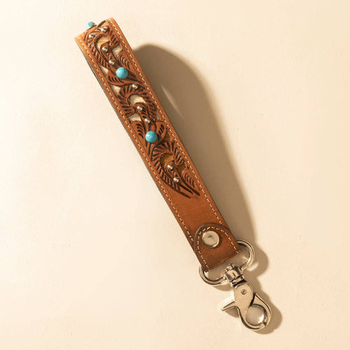 Decorative leather strap with metal clasp on a beige background