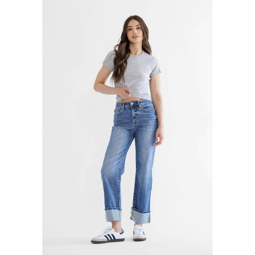Woman wearing blue jeans and a gray crop top on a white background