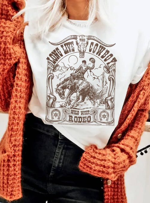 Person wearing a white sweatshirt with a cowboy graphic design, paired with an orange sweater.