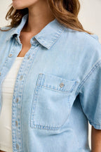 Light blue denim shirt worn by a person with a neutral background