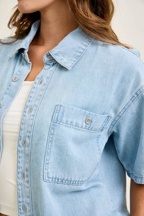 Light blue denim shirt worn by a person with a neutral background