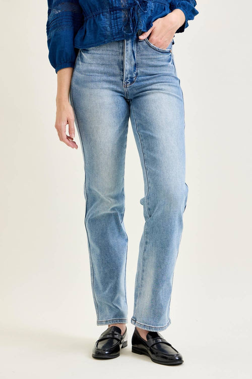 Person wearing light blue jeans and a blue top on a white background