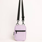 Purple crossbody bag with black straps on a light gray background