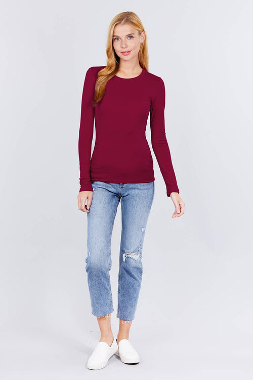 Woman wearing a burgundy sweater and light blue jeans on a white background