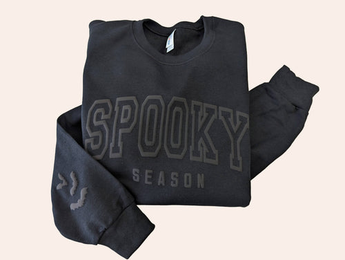 black crewneck with spooky season wrote on it on white background 