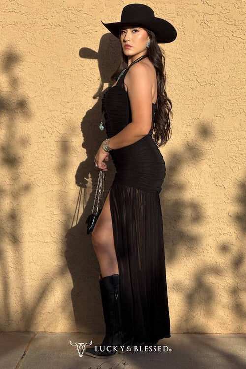 Woman in a black dress and cowboy hat against a beige wall with 'Lucky & Blessed' branding.
