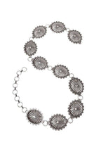 Silver belt with sunburst designs on a white background