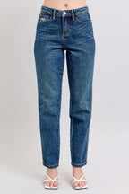 Blue jeans worn by a person on a plain background
