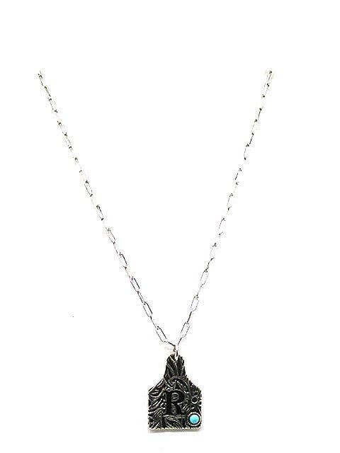 Necklace with a decorative pendant featuring a turquoise stone on a white background