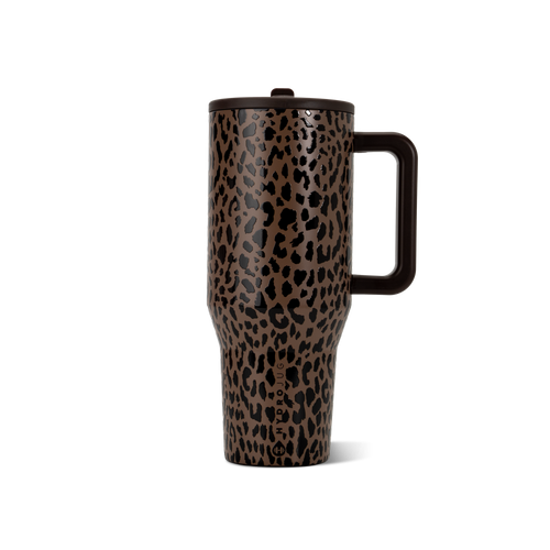 A tall travel tumbler with a brown and black leopard print pattern, featuring a dark brown handle and lid, shown on a clean white background.