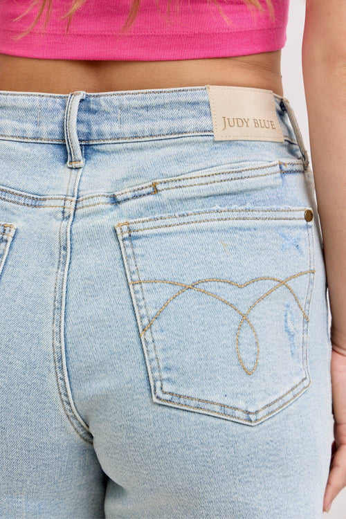Light blue denim jeans with a brand label on the back pocket, worn by a person.