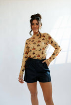 Women Wearing a beige blouse with brands and cowboys on it 