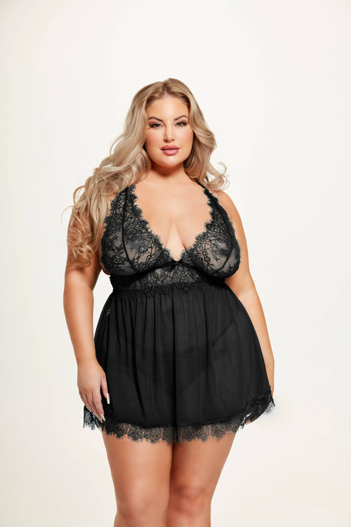 Woman wearing a black lace lingerie set on a plain background