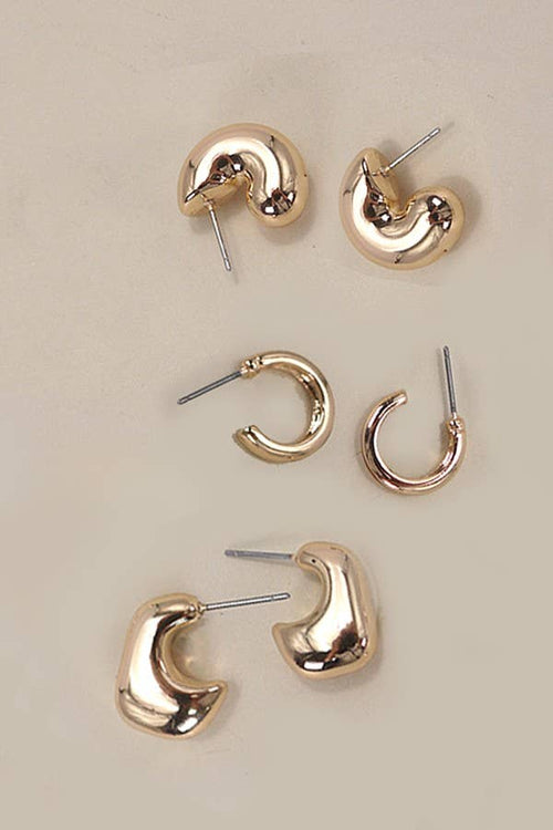 Set of gold hoop earrings on a beige background