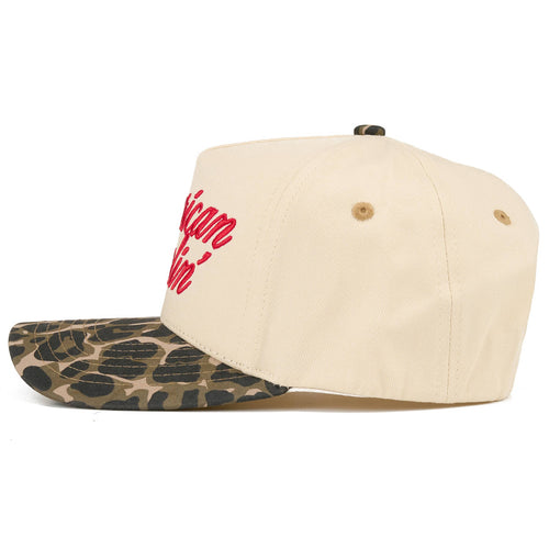 Beige cap with red text and camouflage visor on a white background