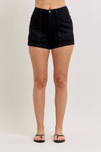 Person wearing black shorts on a plain background