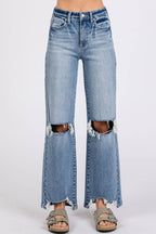 Distressed blue jeans on a white background