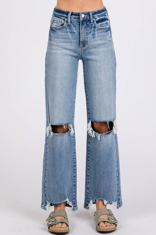 Distressed blue jeans on a white background