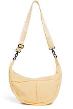 A light yellow crescent-shaped crossbody bag with a matching adjustable shoulder strap featuring the brand name 'Brixton' printed repeatedly, shown on a plain white background.
