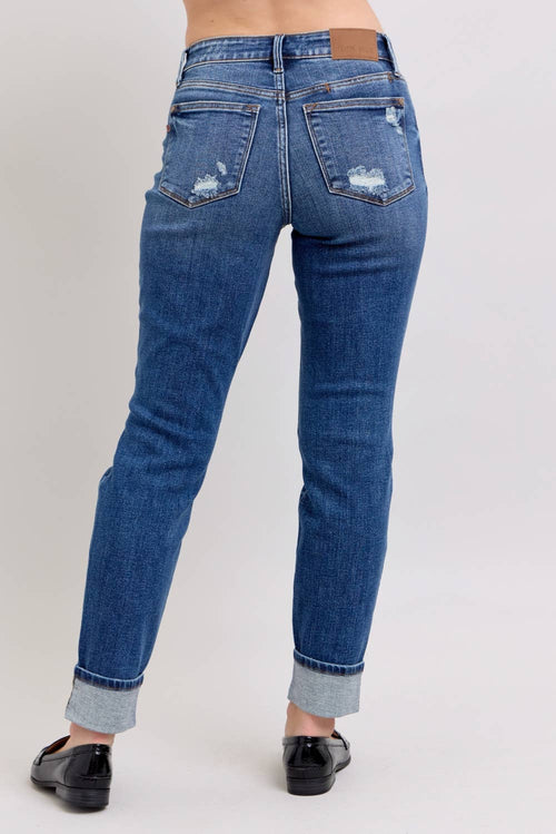 Blue jeans worn by a person on a plain background