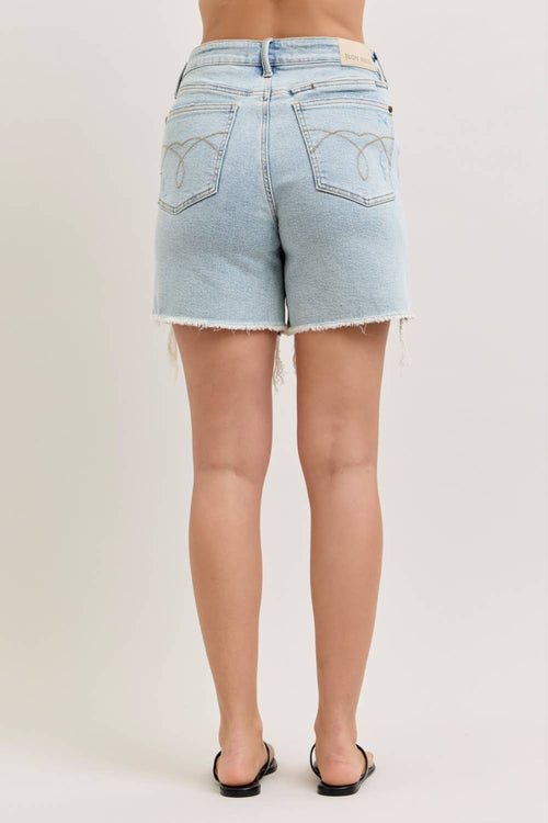 Light blue denim shorts worn by a person on a plain background