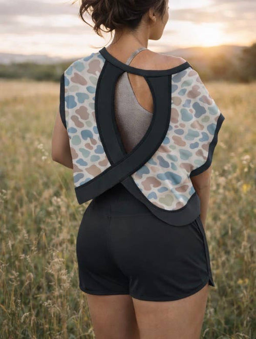 Person wearing a patterned sports bra and shorts in a field