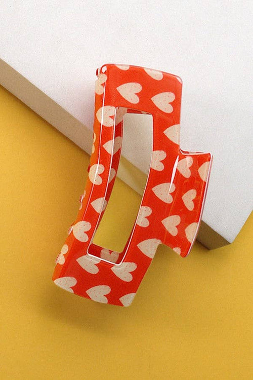 Red and white heart pattern clip on a yellow background