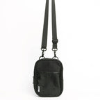 Black crossbody bag with a strap on a white background