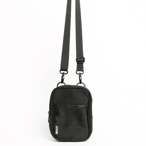 Black crossbody bag with a strap on a white background