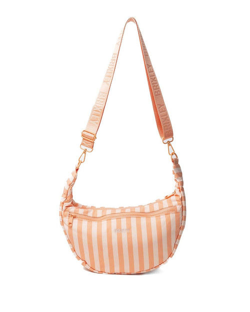 A crescent-shaped shoulder bag with vertical peach and white stripes, featuring a matching patterned shoulder strap with gold-tone hardware.