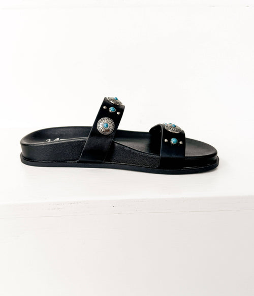 Black sandal with decorative straps on a white background
