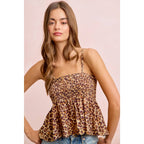 Woman wearing a leopard print top against a pink background