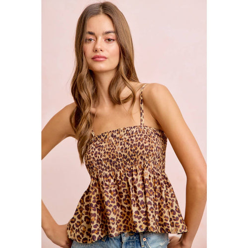 Woman wearing a leopard print top against a pink background