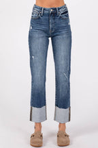 Blue jeans with distressed details on a white background