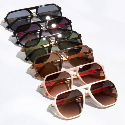 Set of sunglasses with different colored lenses arranged on a white surface